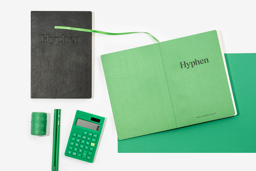Open notebook with green printed endpapers and debossed black faux leather notebook cover